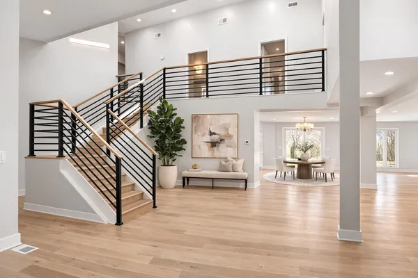 a hallway with a white couches and potted plants with wooden floor