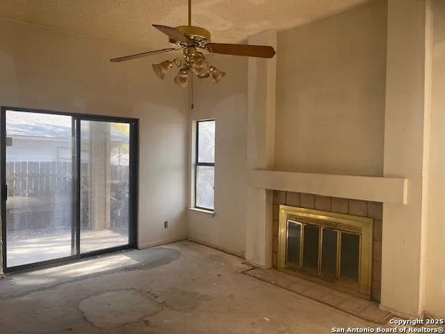 an empty room with a fireplace and fan