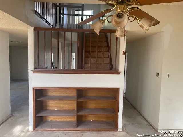 an empty room with windows and fan