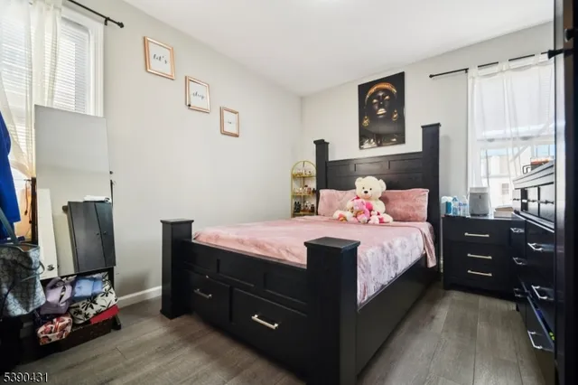 a bedroom with a bed and a flat tv screen on the dresser