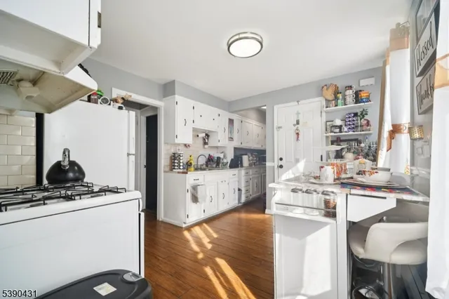 a kitchen with white cabinets and appliances