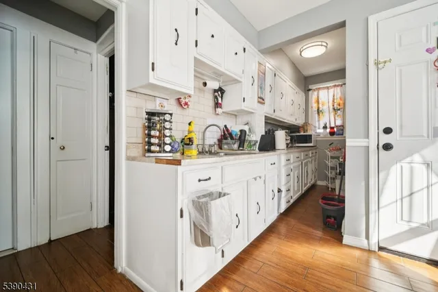 a kitchen with stainless steel appliances sink cabinets and wooden floor