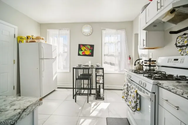 a kitchen with stainless steel appliances a stove a sink cabinets and a refrigerator