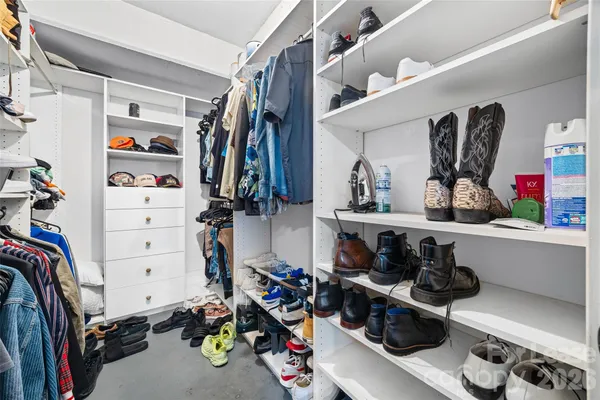 a view of walk in closet with clothes and shoes