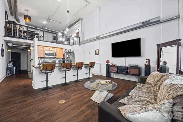 a living room with furniture a flat screen tv and kitchen view