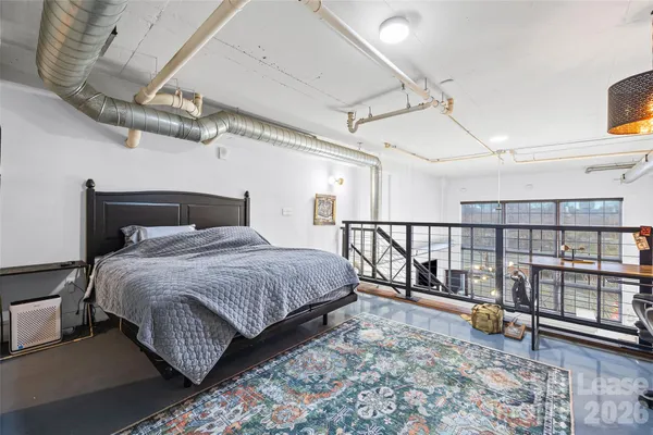 a bedroom with a bed a books bucket with a large window