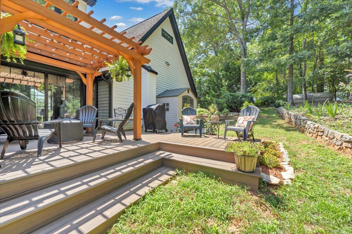 3851 Joppa Mill Road Moneta, VA 24121 - Photo 15 of 104 a view of a patio with table and chairs potted plants and floor to ceiling window