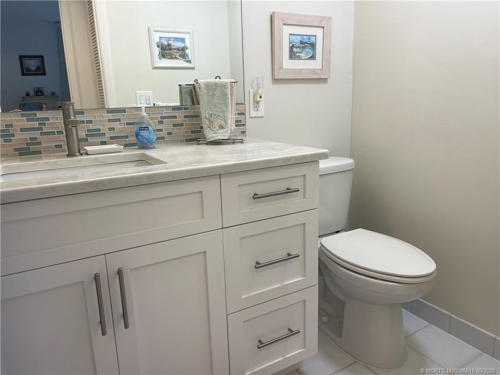 1858 Southwest Palm City Road, Unit 203 Stuart, FL 34994 - Photo 19 of 21 a bathroom with a toilet sink and mirror