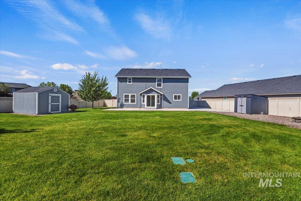 12310 West Hidden Point Drive Star, ID 83669 - Photo 41 of 48 Expansive backyard featuring a manicured lawn, a detached storage shed, a paved patio, and perimeter fencing