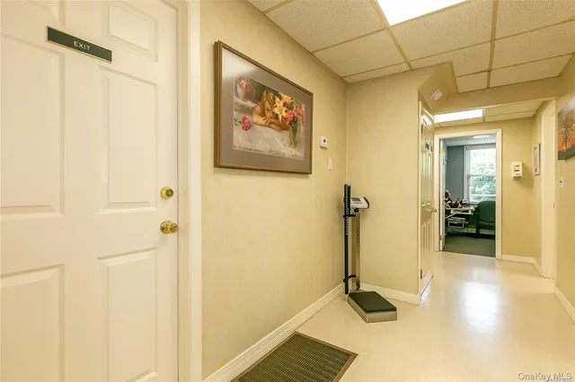 a view of a hallway with wooden floor and a bathroom