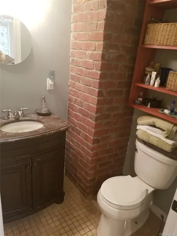 a bathroom with a granite countertop toilet and a sink