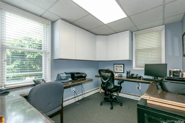 a view of a workspace with furniture and a window