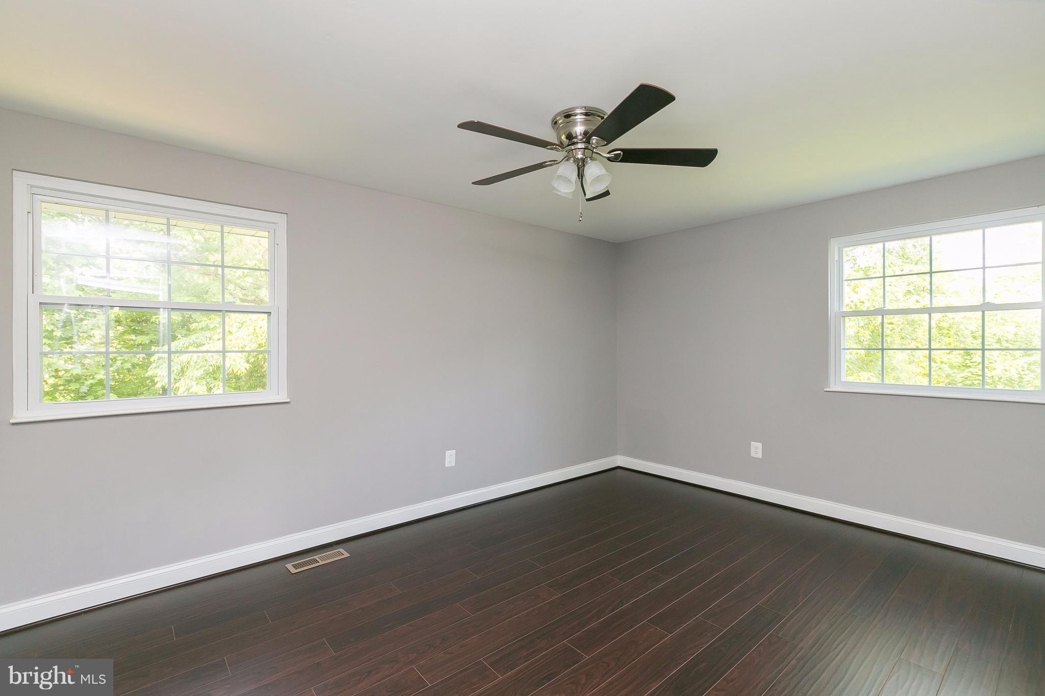 8621 Pilsen Road Randallstown, MD 21133 - Photo 11 of 26 a view of a big room with wooden floor and windows