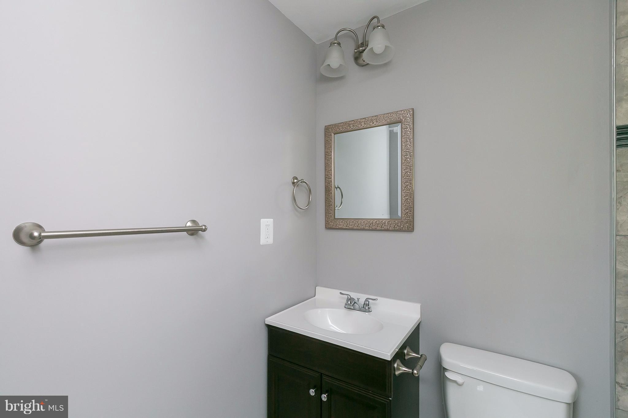 8621 Pilsen Road Randallstown, MD 21133 - Photo 13 of 26 a bathroom with a toilet sink vanity and mirror