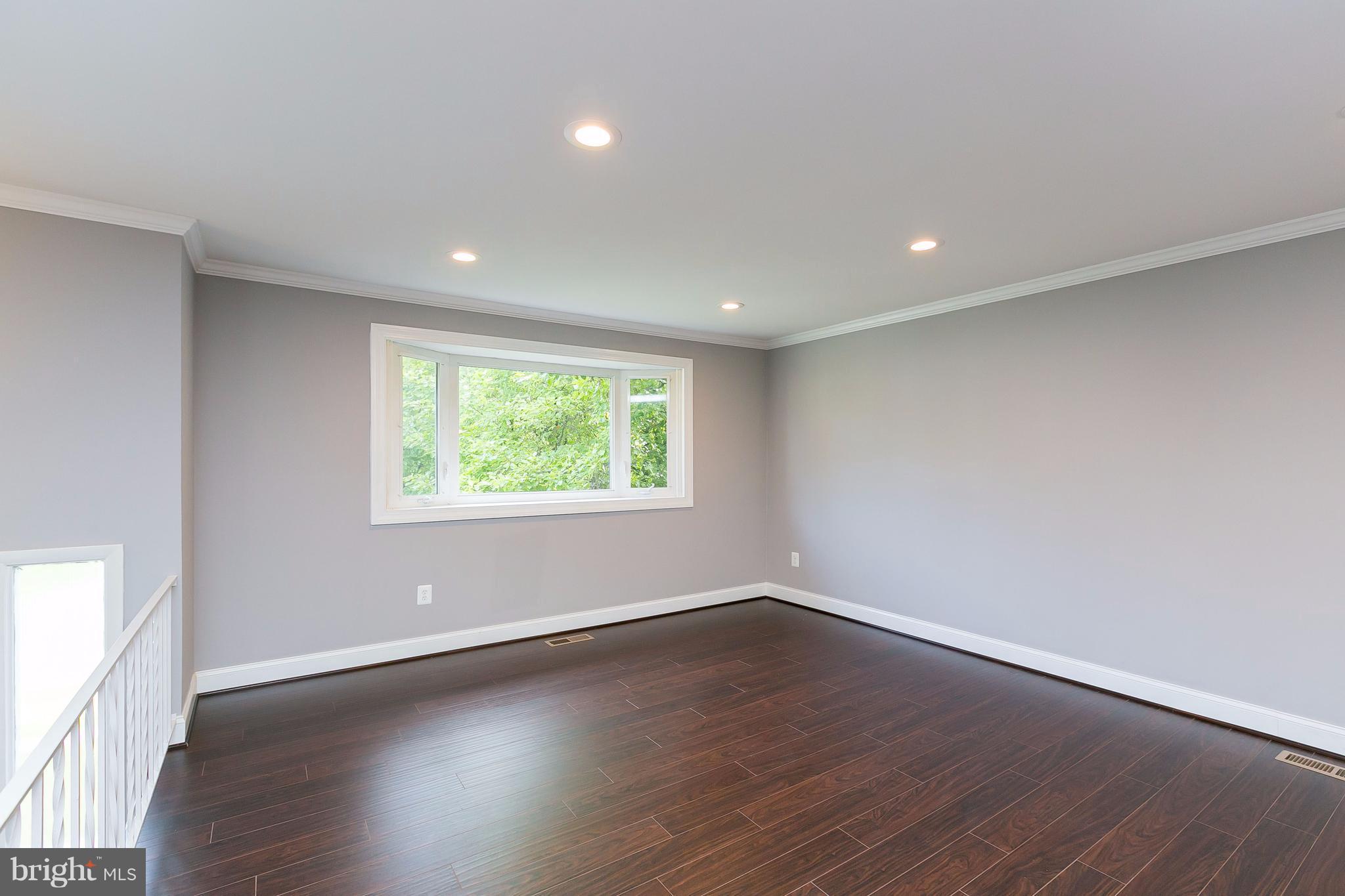 8621 Pilsen Road Randallstown, MD 21133 - Photo 4 of 26 an empty room with wooden floor and windows