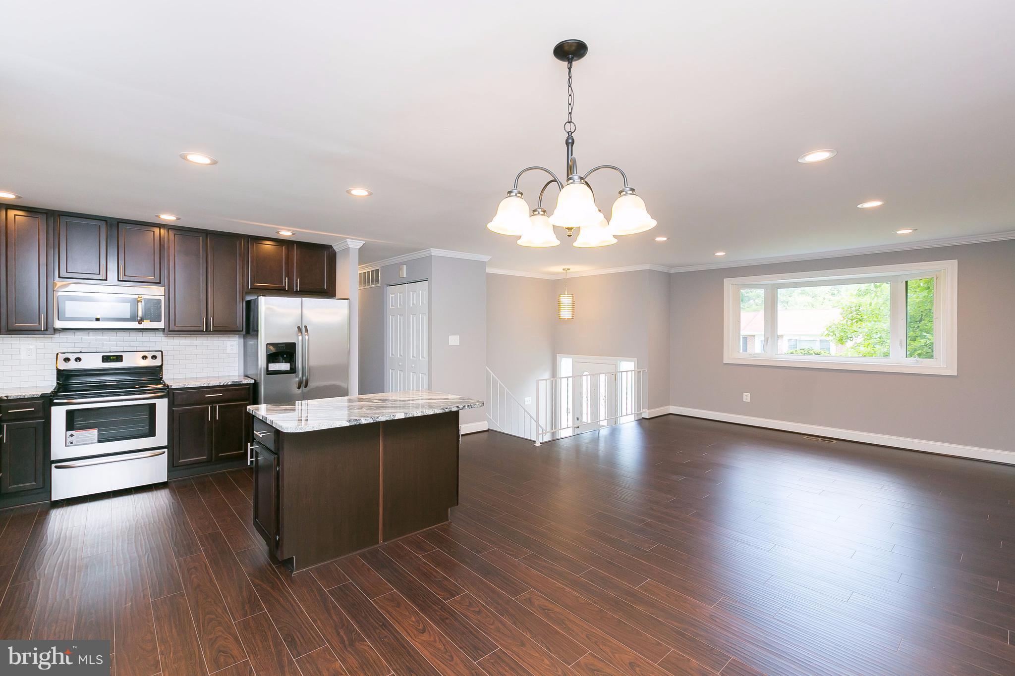 8621 Pilsen Road Randallstown, MD 21133 - Photo 6 of 26 a kitchen with stainless steel appliances granite countertop a stove and a wooden floors