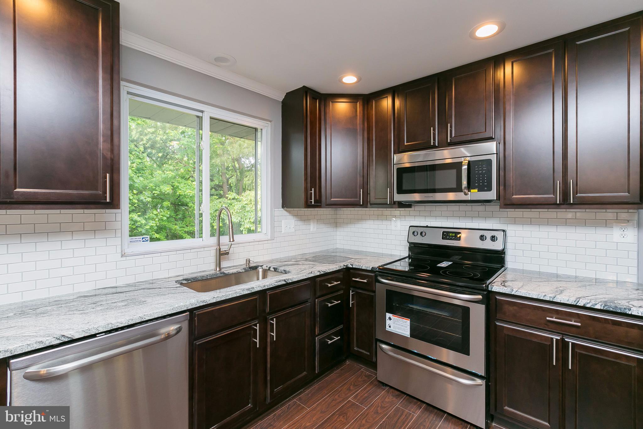 8621 Pilsen Road Randallstown, MD 21133 - Photo 9 of 26 a kitchen with stainless steel appliances granite countertop a sink and stove top oven