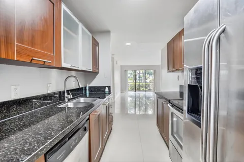 a kitchen with granite countertop a sink stove and refrigerator