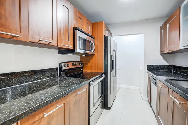 a kitchen with stainless steel appliances a refrigerator and a stove top oven