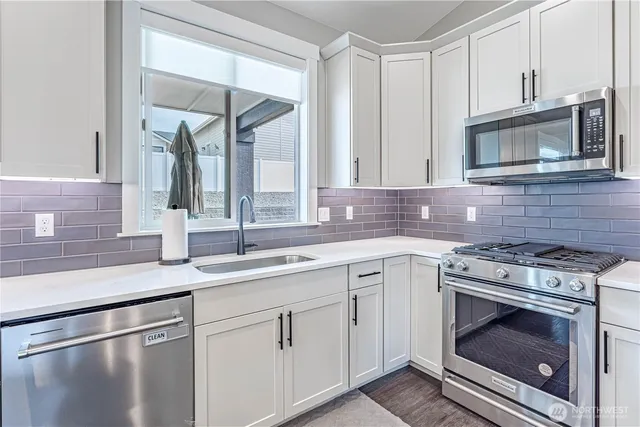 a kitchen with cabinets stainless steel appliances and a sink