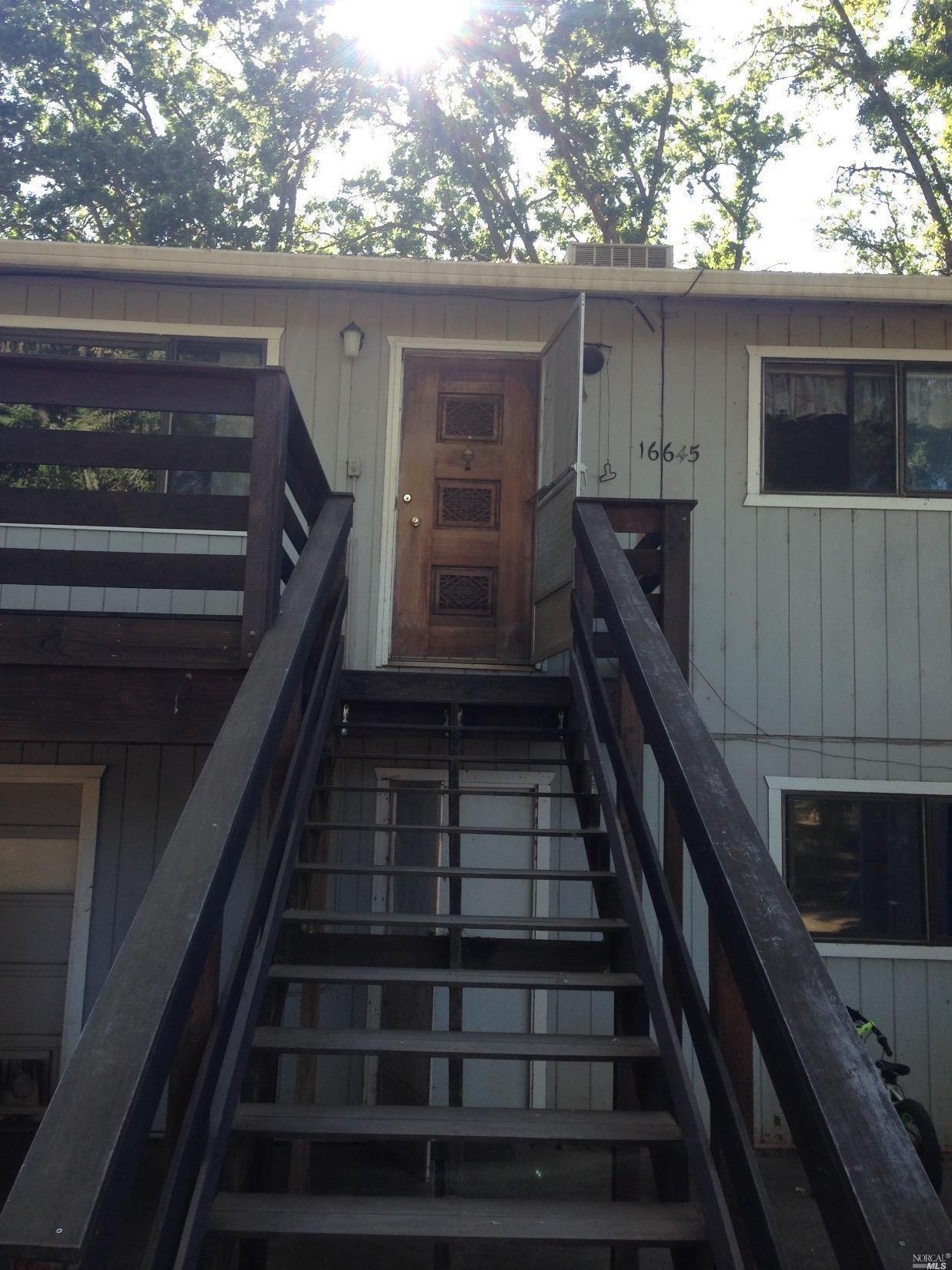 Stairs to front porch, below left is converted attached garage w/ auto door + separate entry.