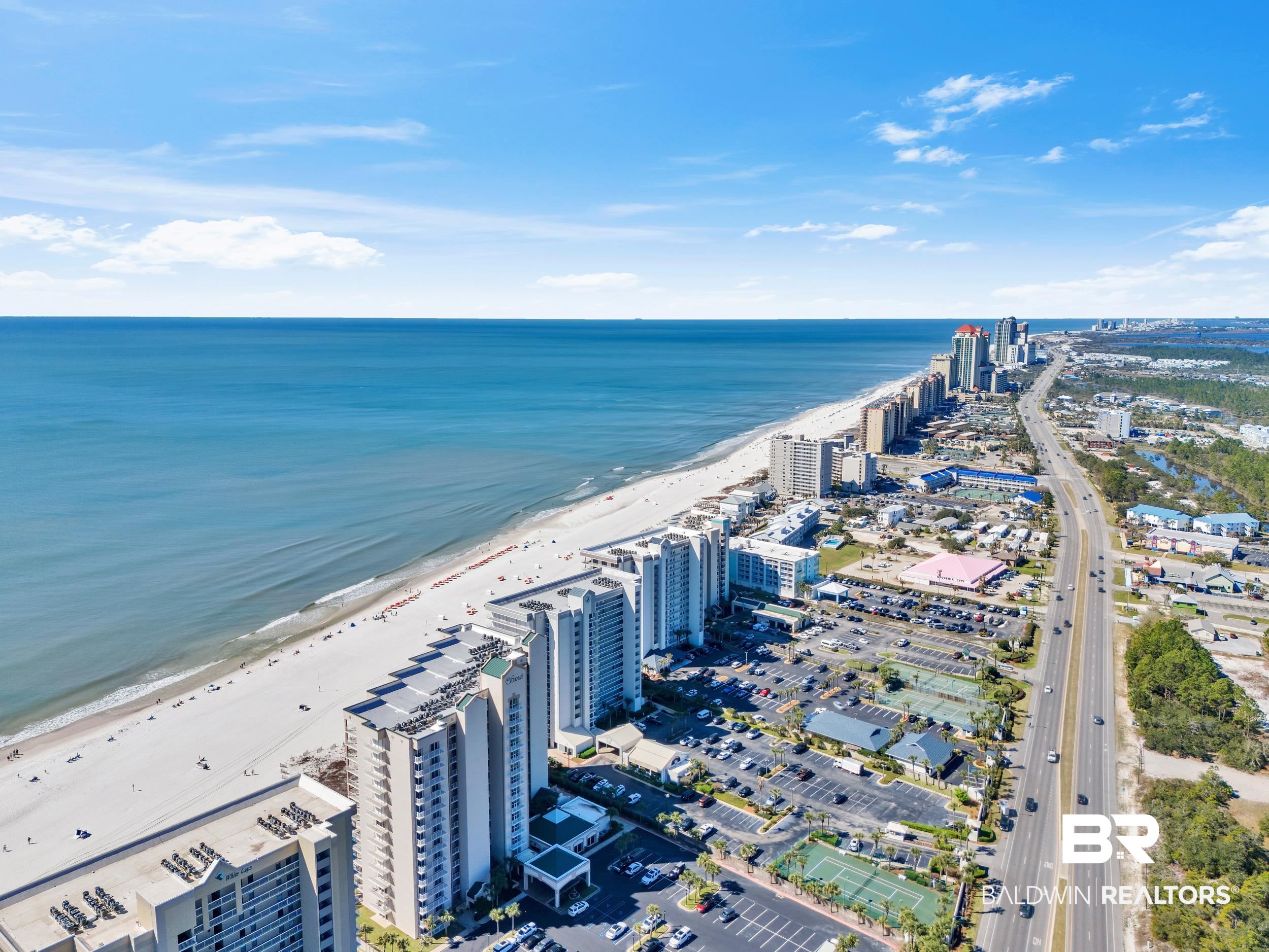 3256 Loop Road, Unit 2 Orange Beach, AL 36561 - Photo 7 of 25 Coastal high-rise buildings line a white sand beach fronting the expansive blue ocean