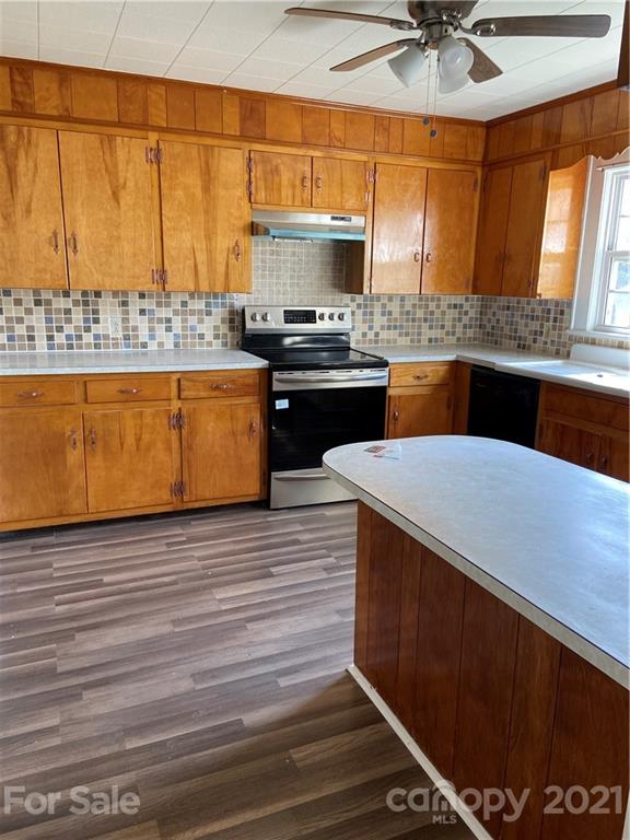 883 State Rd S-29-376 Lancaster, SC 29720 - Photo 12 of 16 a kitchen with stainless steel appliances kitchen island granite countertop a sink wooden cabinets and a granite counter top