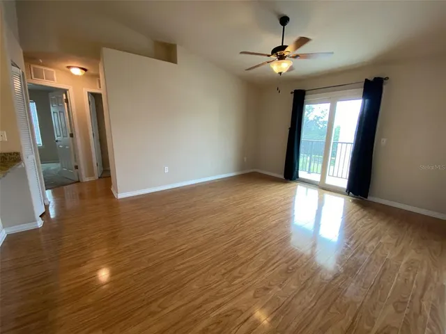 a view of a kitchen with stainless steel appliances wooden floor and a large window