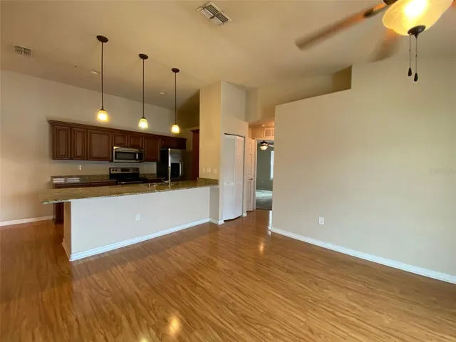 a view of a hallway with wooden floor and staircase
