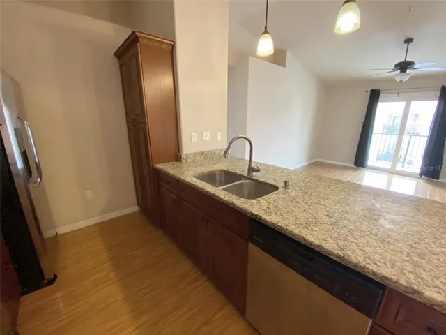 a kitchen with granite countertop sink and refrigerator