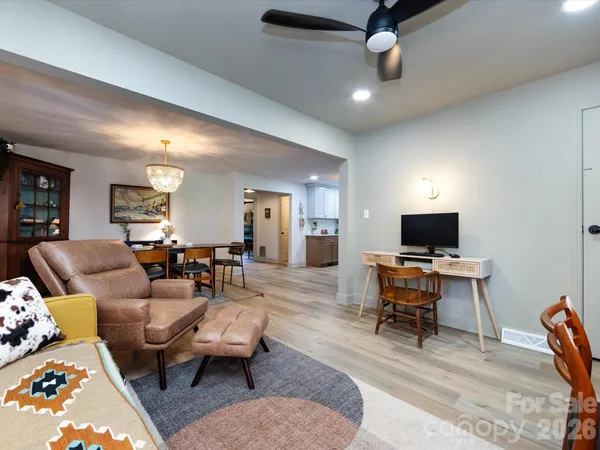 a living room with furniture a flat screen tv and a window