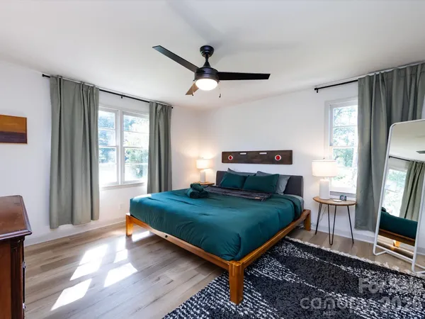a bedroom with a bed window and a flat screen tv