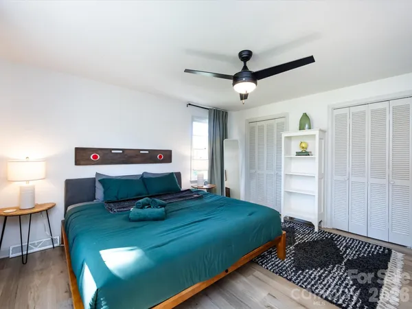 a bedroom with a bed and wooden floor