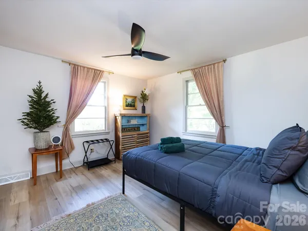 a bedroom with a bed and wooden floor