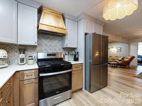 a kitchen with a stove a refrigerator and a microwave