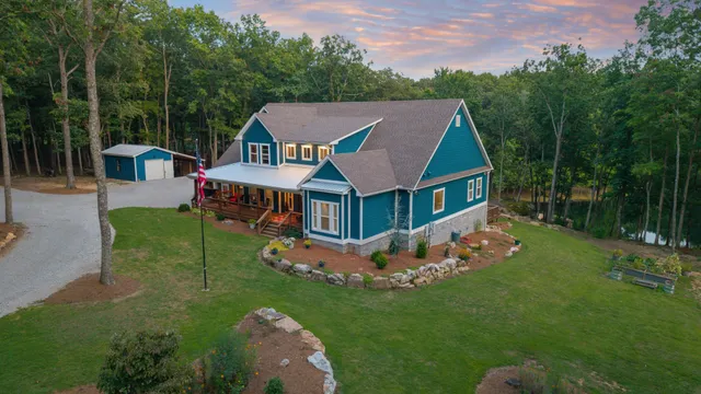 a aerial view of a house with a big yard potted plants and large tree