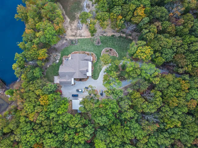 an aerial view of a house with a yard and lake view