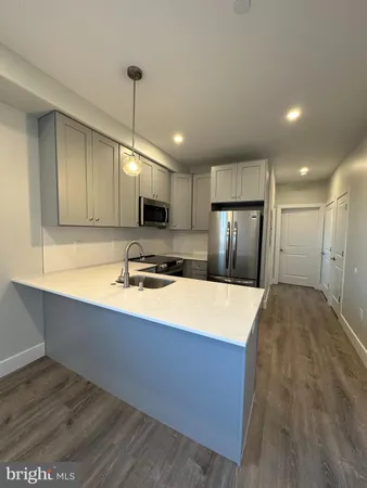 a large kitchen with kitchen island a sink stainless steel appliances and cabinets
