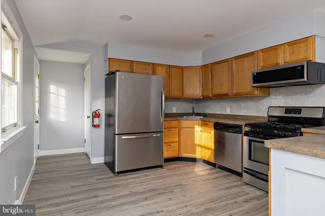 a kitchen with granite countertop wooden floors and stainless steel appliances