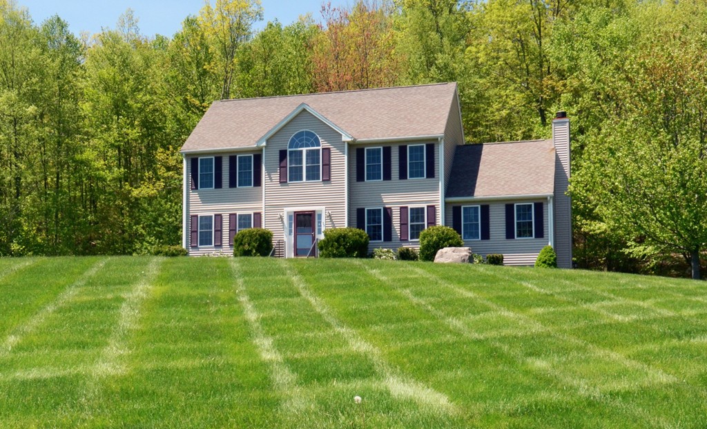 33 Quabbin Path Sutton, MA 01590 - Photo 1 of 27 a front view of a house with a yard and trees