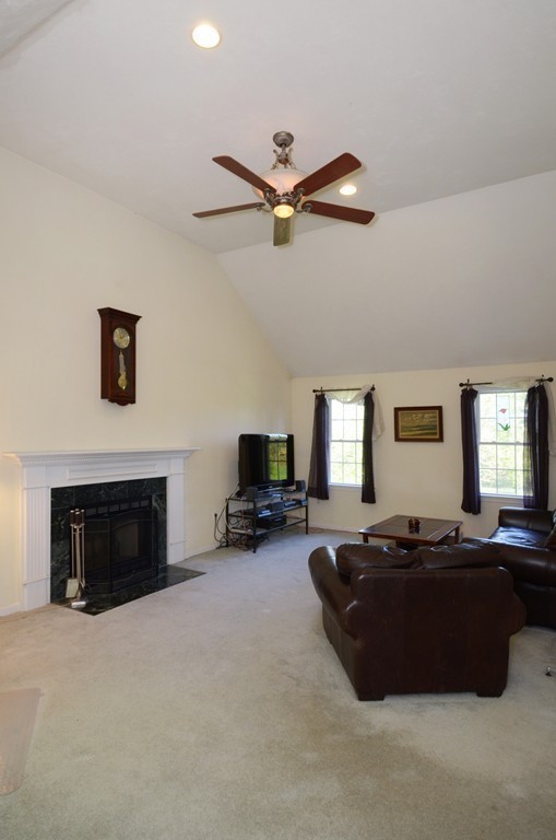 33 Quabbin Path Sutton, MA 01590 - Photo 14 of 27 a living room with furniture flat screen tv and a fireplace