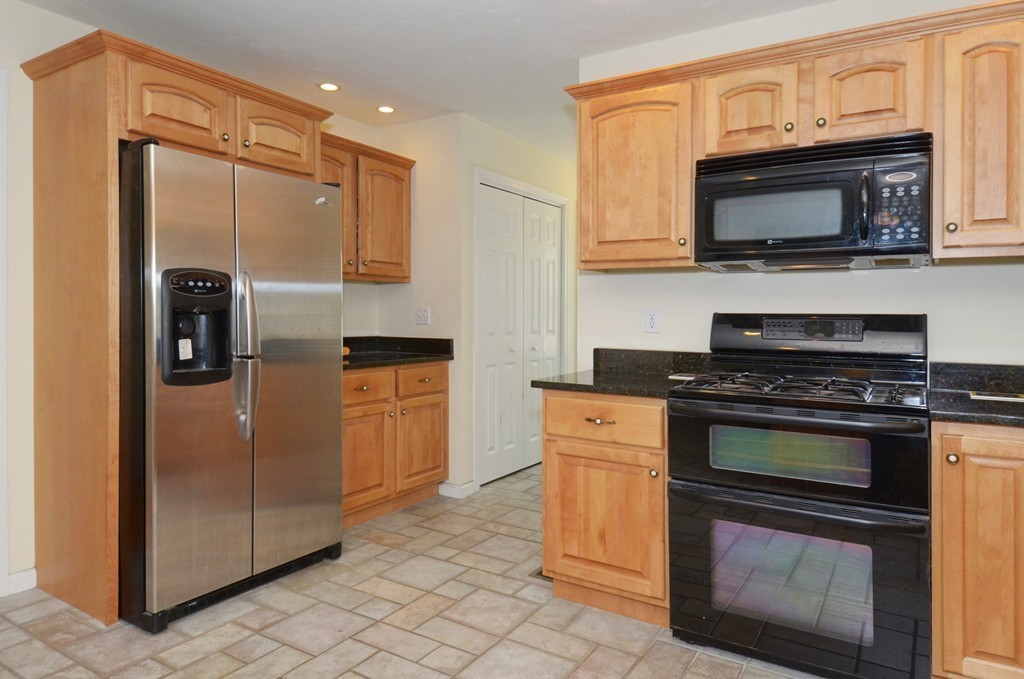 33 Quabbin Path Sutton, MA 01590 - Photo 4 of 27 a kitchen with stainless steel appliances granite countertop a stove microwave and refrigerator