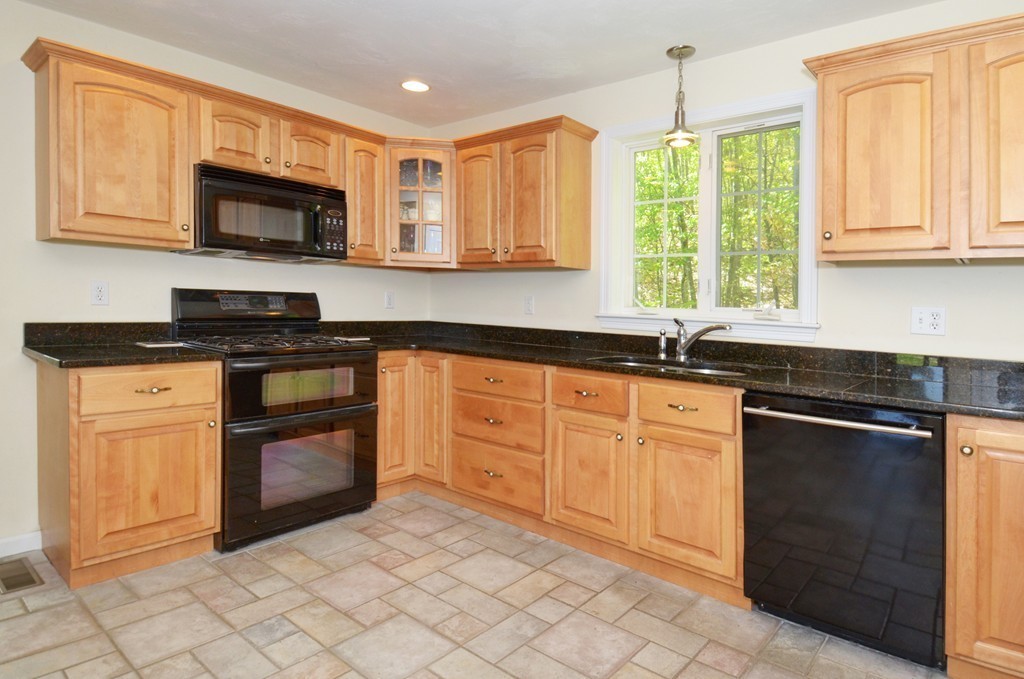 33 Quabbin Path Sutton, MA 01590 - Photo 6 of 27 a kitchen with granite countertop white cabinets and stainless steel appliances