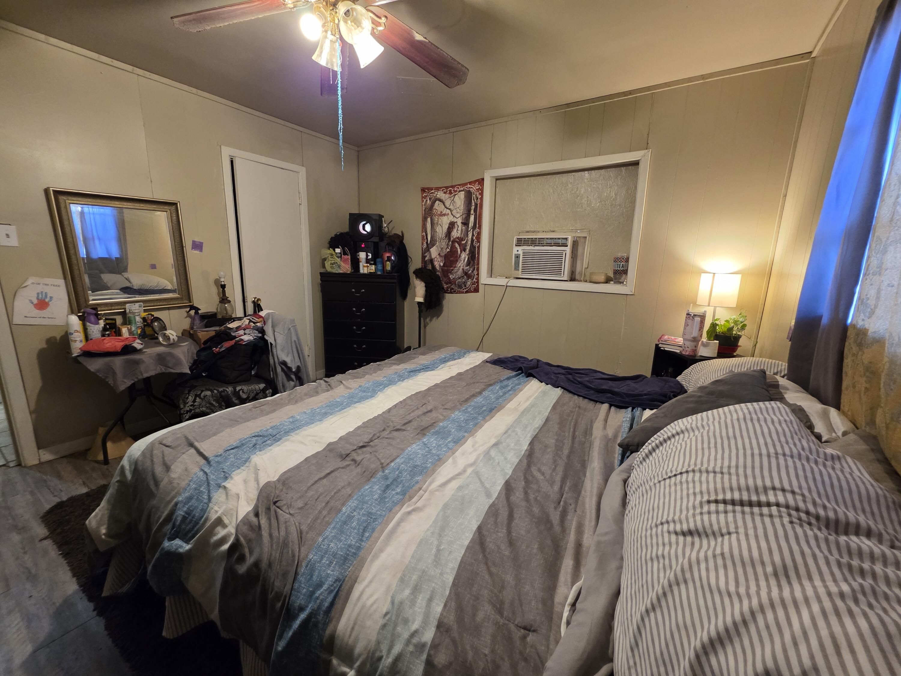 2105 East 29th Street Lubbock, TX 79404 - Photo 17 of 26 a bedroom with a bed and a chandelier