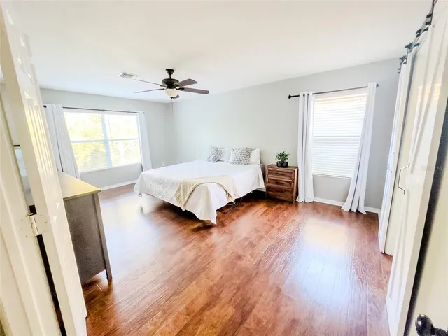 a bedroom with a bed and wooden floor