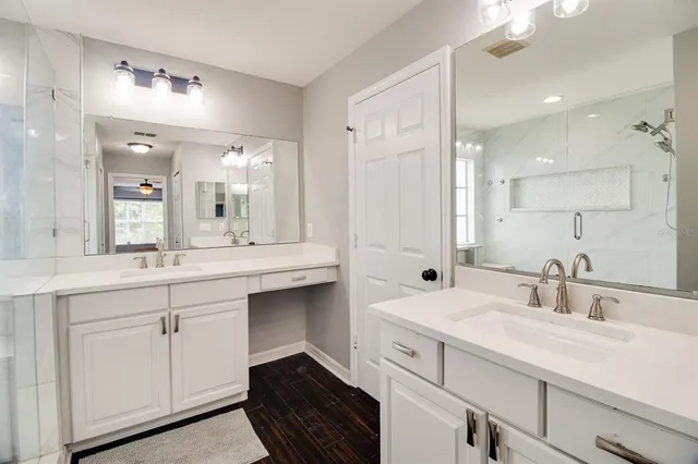 a bathroom with double vanity and a mirror