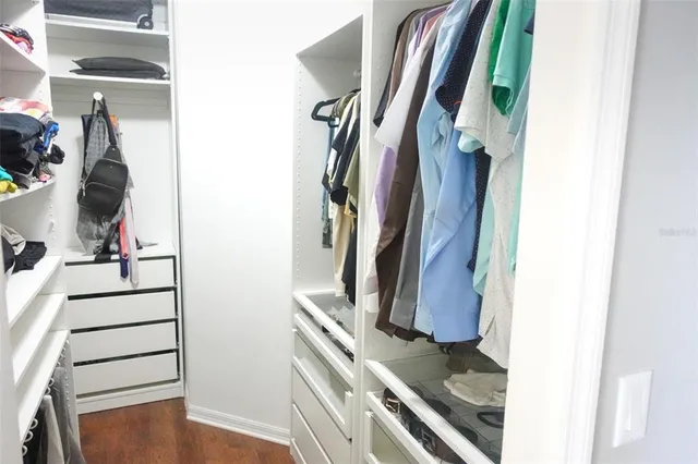 a view of walk in closet with clothes and shoes