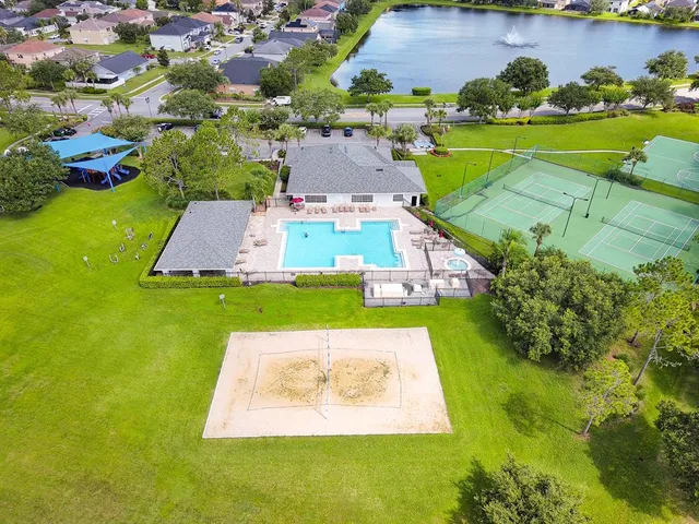 an aerial view of a house with swimming pool big yard and large trees