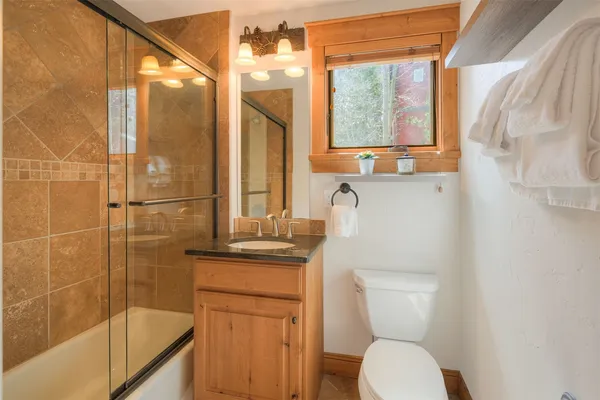 a bathroom with a granite countertop sink toilet and shower