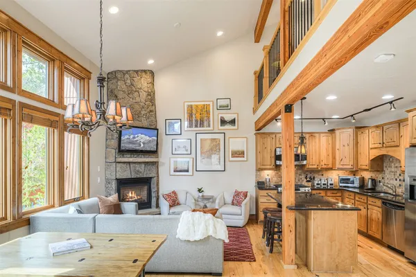 a living room with furniture a fireplace and a dining table wooden floor